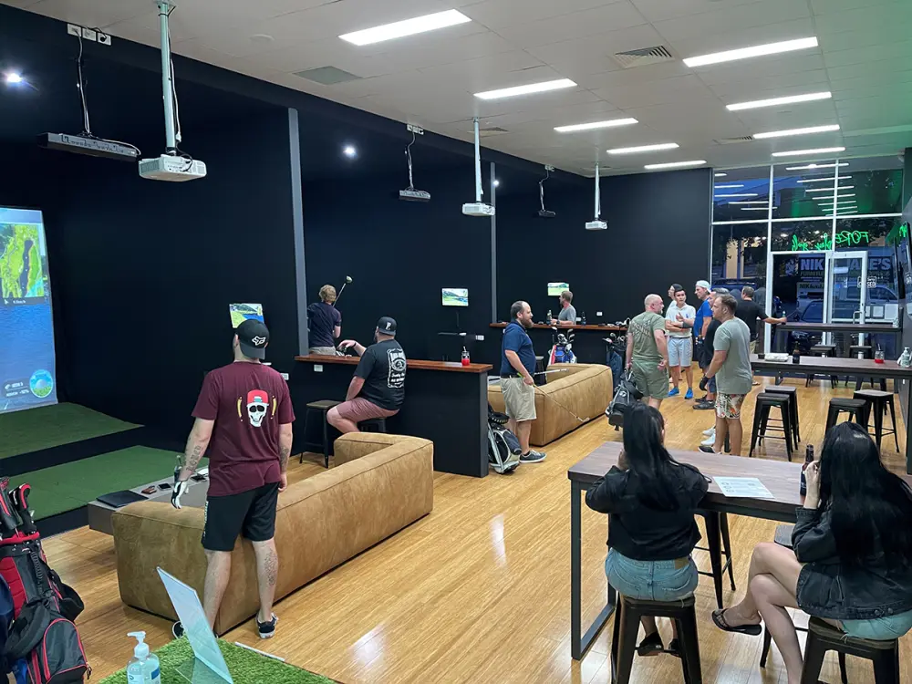 The main room on a busy night: players at two bays, mates on the leather couches and the high tables full.